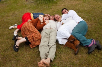 A group of people lying on the ground together, laughing